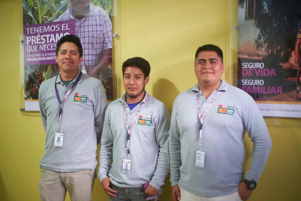 Three representatives of Red Oaxaca standing in a small, local banking branch