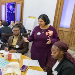 Four participants seated around a table in discussion during a workshop on instant payment systems and financial inclusion.