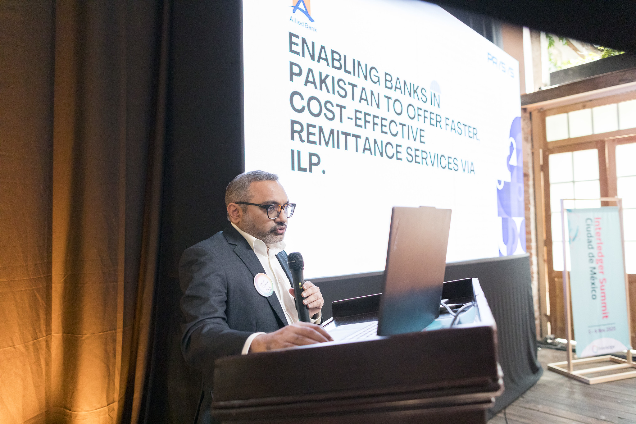 Speaker presenting on enabling banks in Pakistan to offer cost effective remittance services via ILP