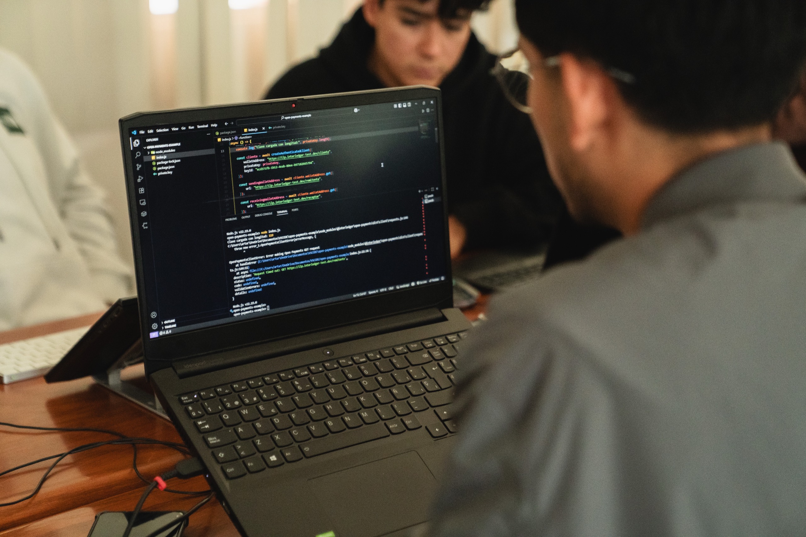 Developers reviewing code on a laptop during an Interledger workshop.